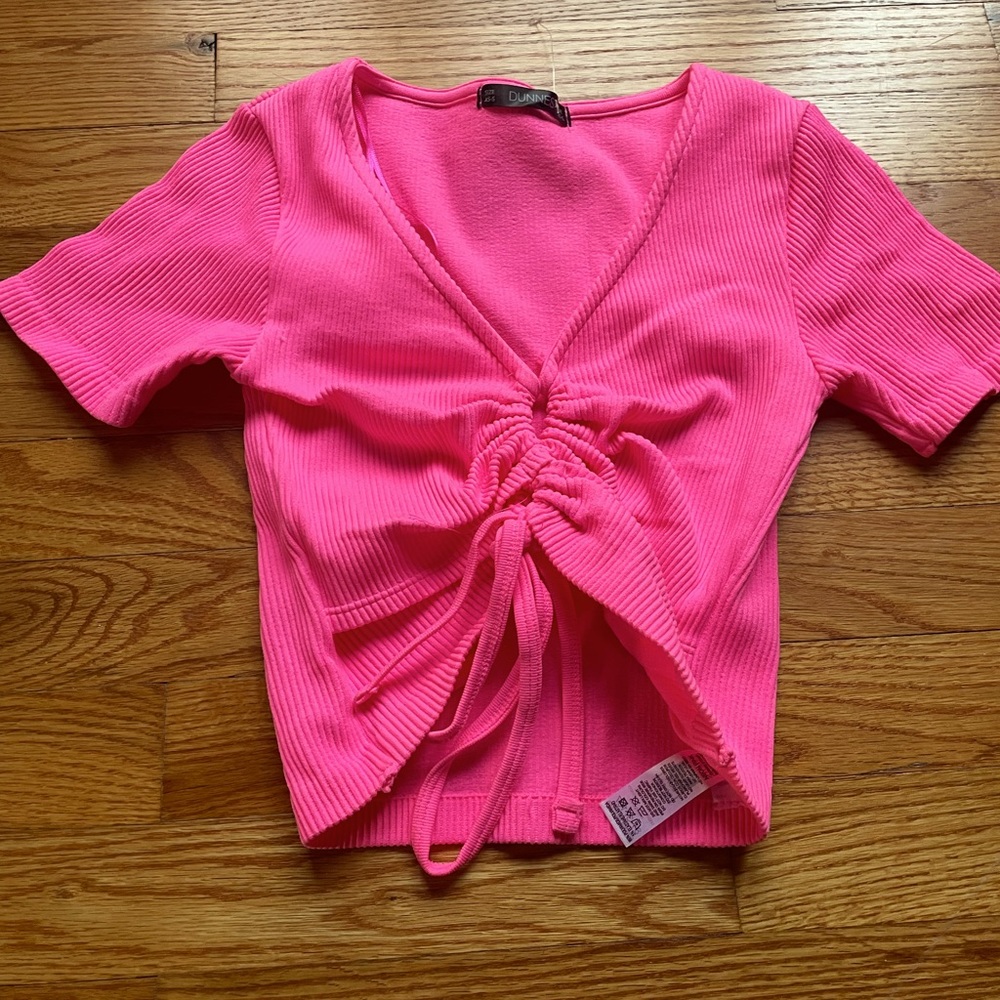 neon pink crop top with bow in the middle